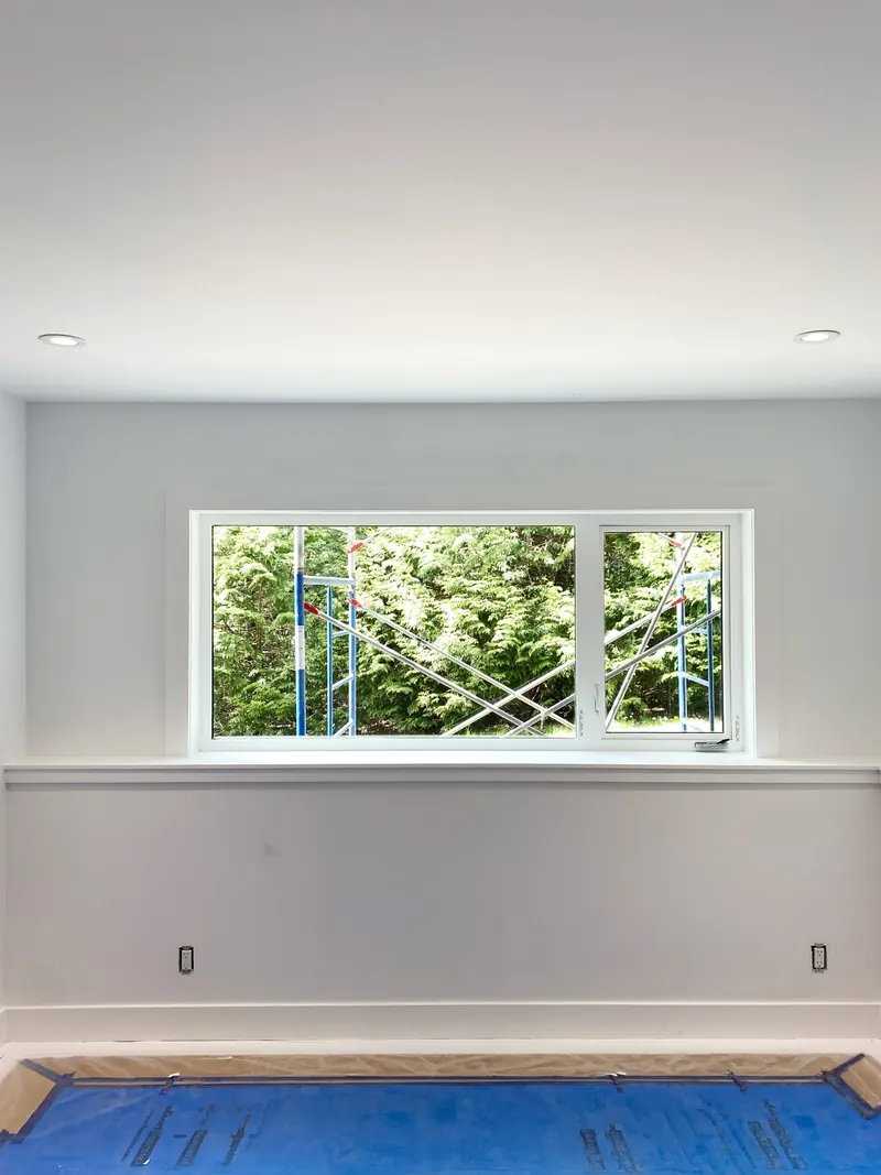 Bright room with freshly painted walls, a deep window sill and trim, floors covered