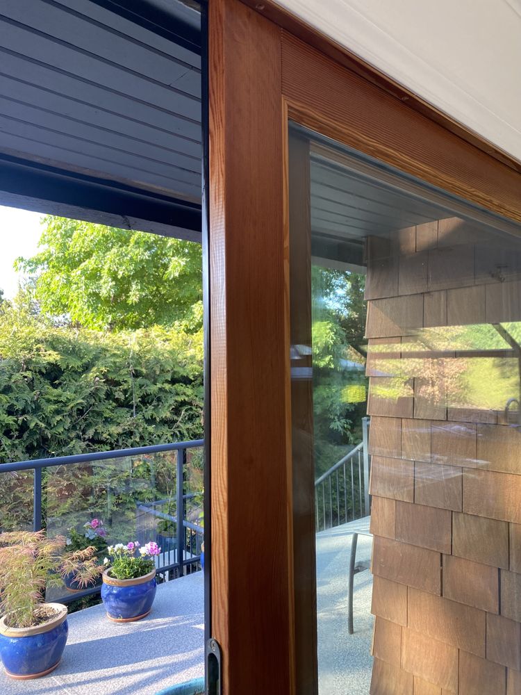 Stained wood door frame beside cedar shingle siding