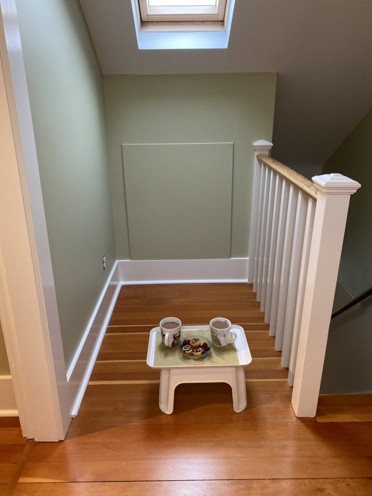 Finished stair landing in Oak Bay with sage-green walls and crisp white trim